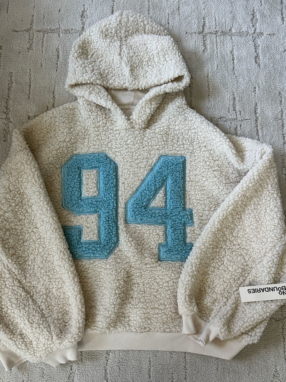 No Boundaries Cream Sherpa Hoodie with Blue 94 Patch
